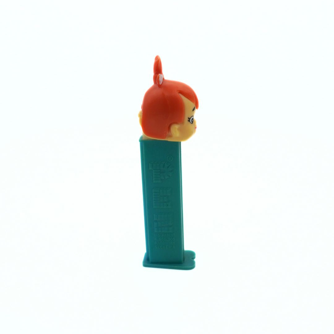 Side on photo of a vintage Pez dispenser of Pebbles from the Flinstones, with a green body