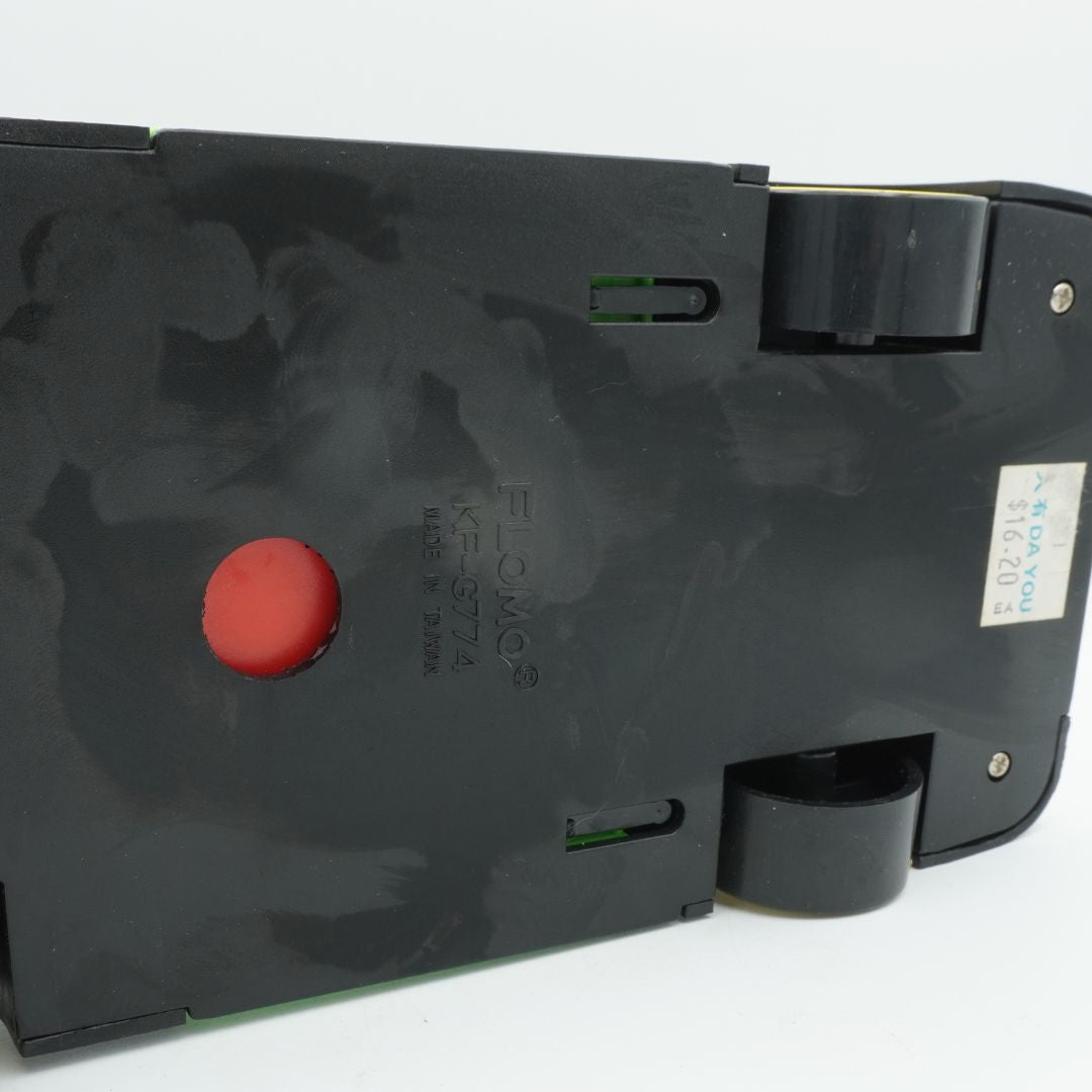 Black electronic device with a red button on a white background