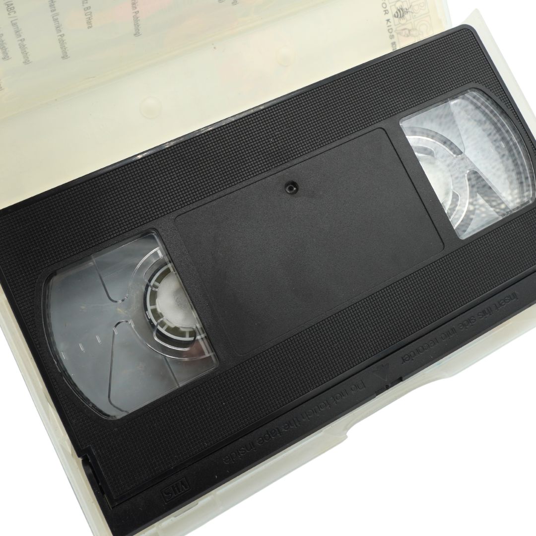 A black VHS video tape partially pulled from a white plastic case, photographed on a white background.