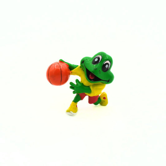 Toy frog holding a red ball on a white background