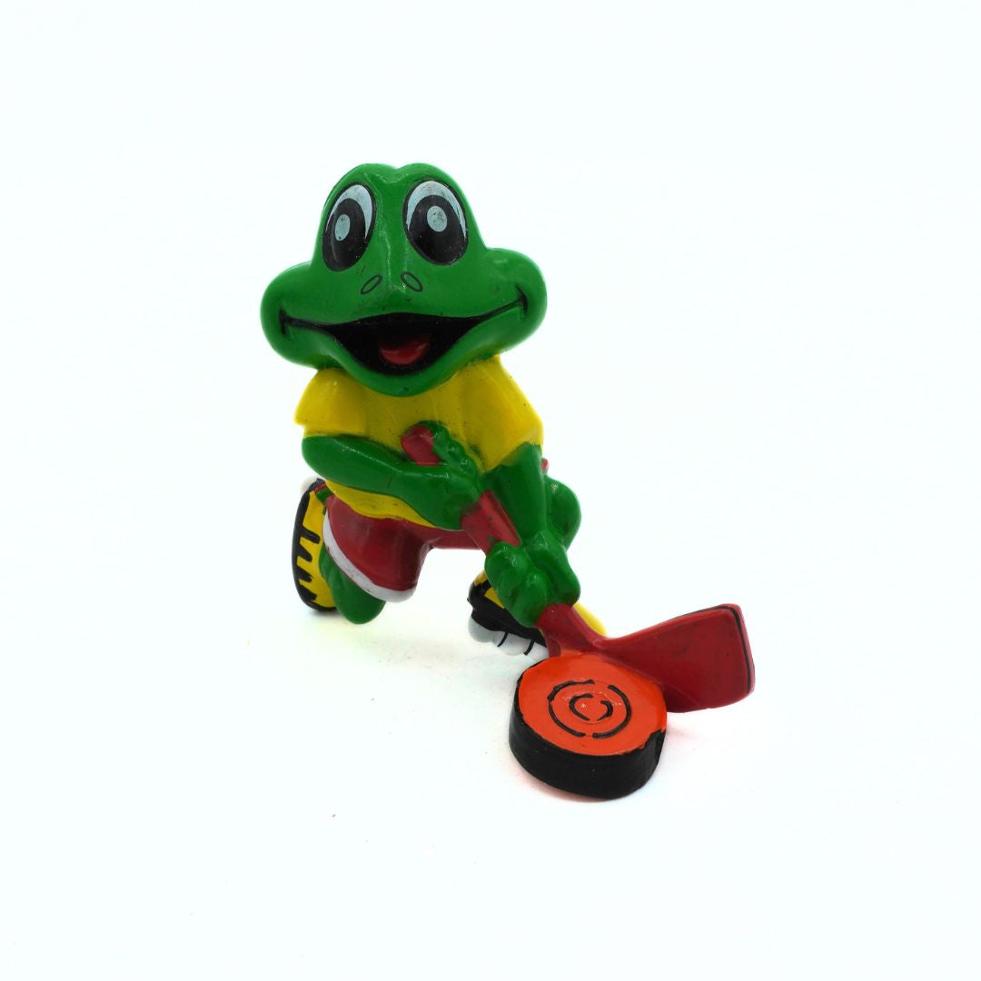 Colorful frog figurine with a red and black object on a white background