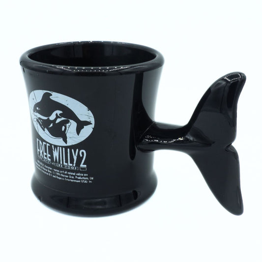Black mug with whale design and 'Free Willy 2' text on a white background