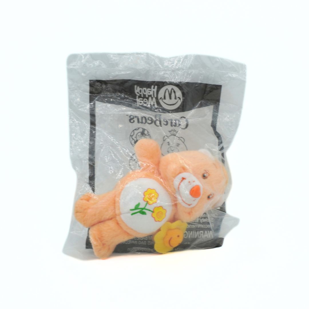Plush toy bear in a McDonald's Happy Meal package on a white background