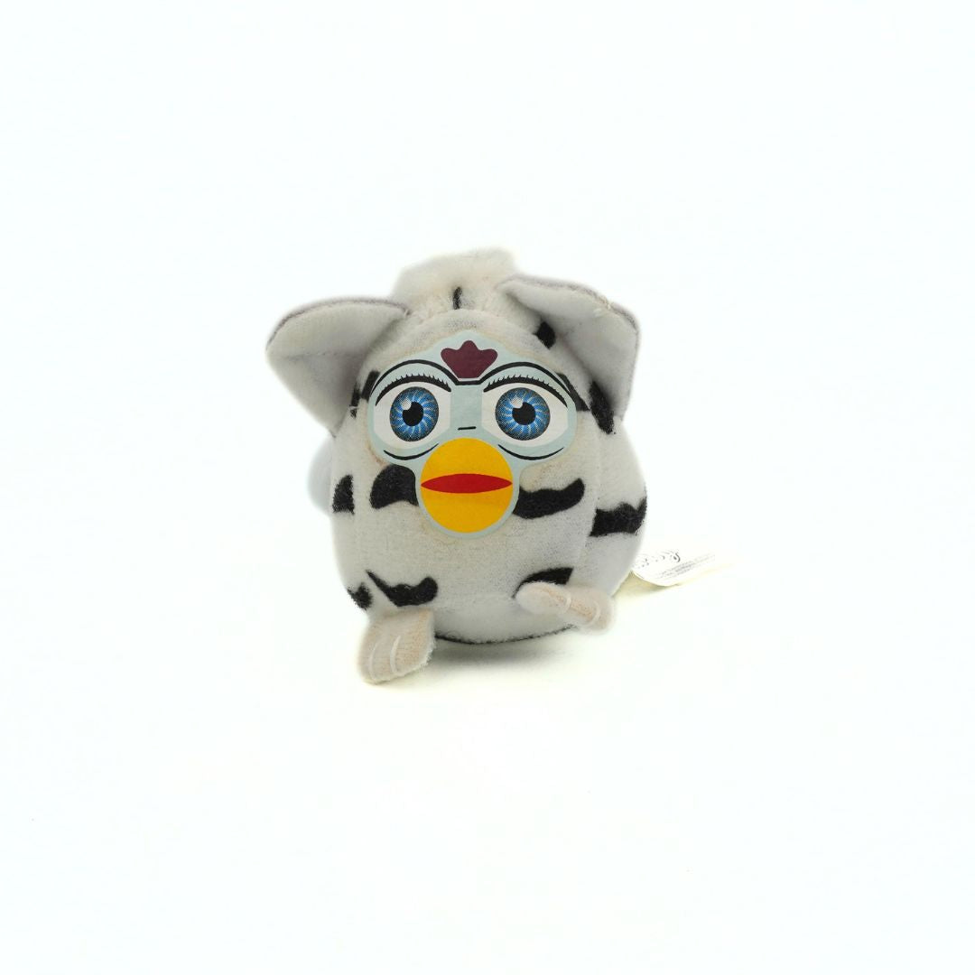 Plush toy resembling a character with blue eyes, black spots, and a yellow beak on a white background