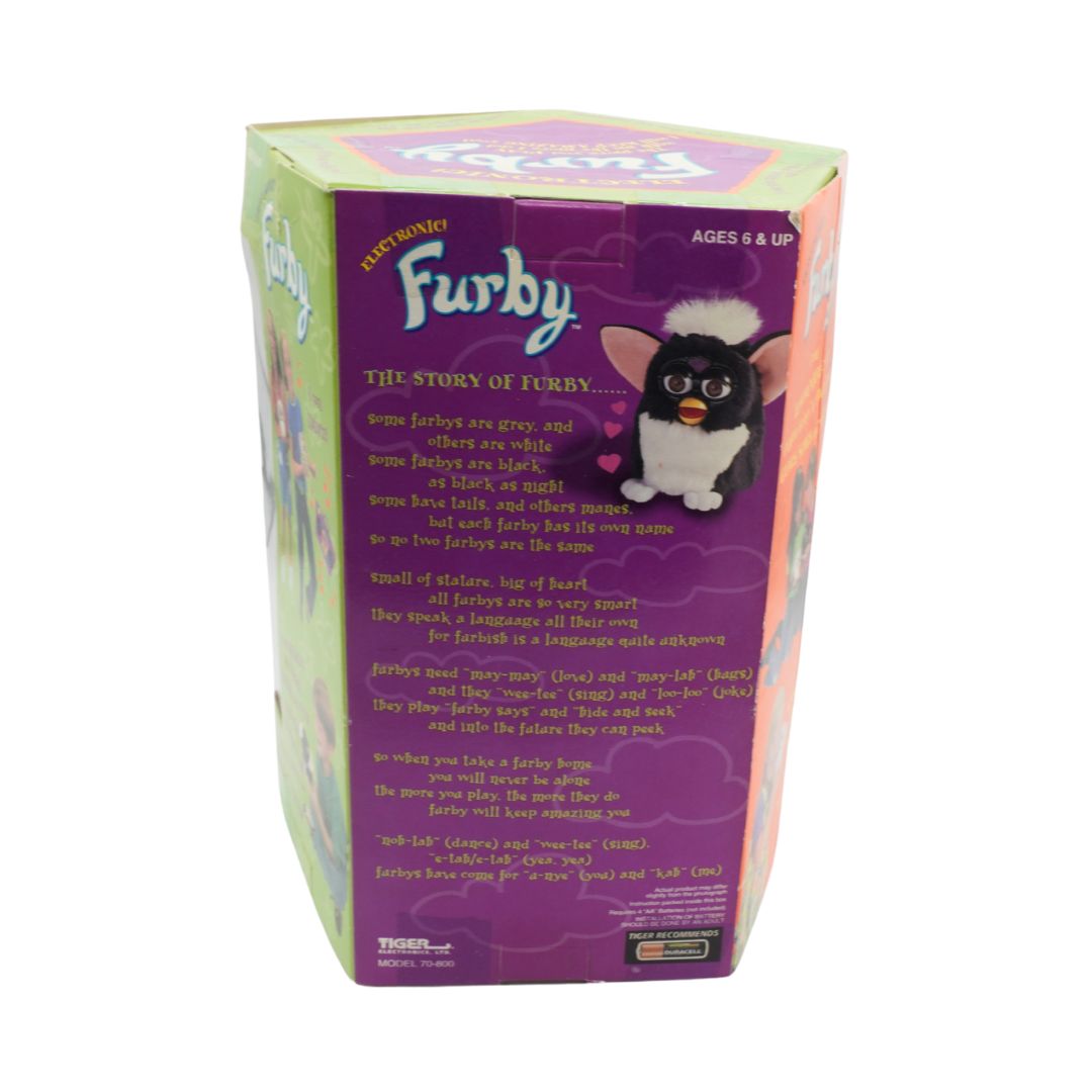 Furby toy packaging with purple back cover featuring text and a black and white Furby illustration.