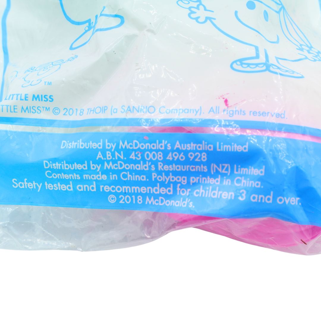 Close-up of a plastic packaging bag for Little Miss, featuring blue cartoon illustrations and printed text including 'Distributed by McDonald's Australia Limited' and '© 2018 McDonald's'.