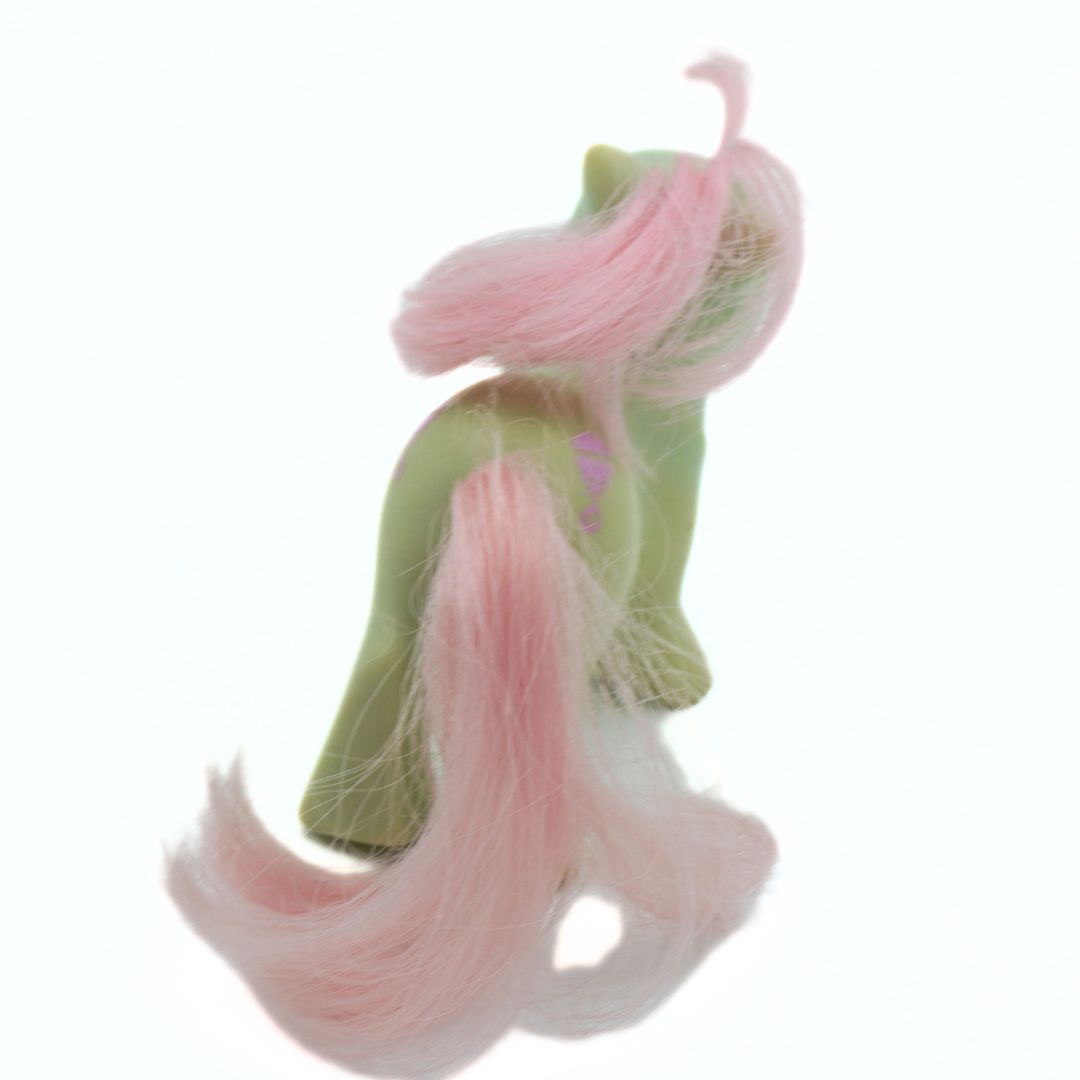 Vintage 1985 My Little Pony doll seen from behind, with pink hair and a green body