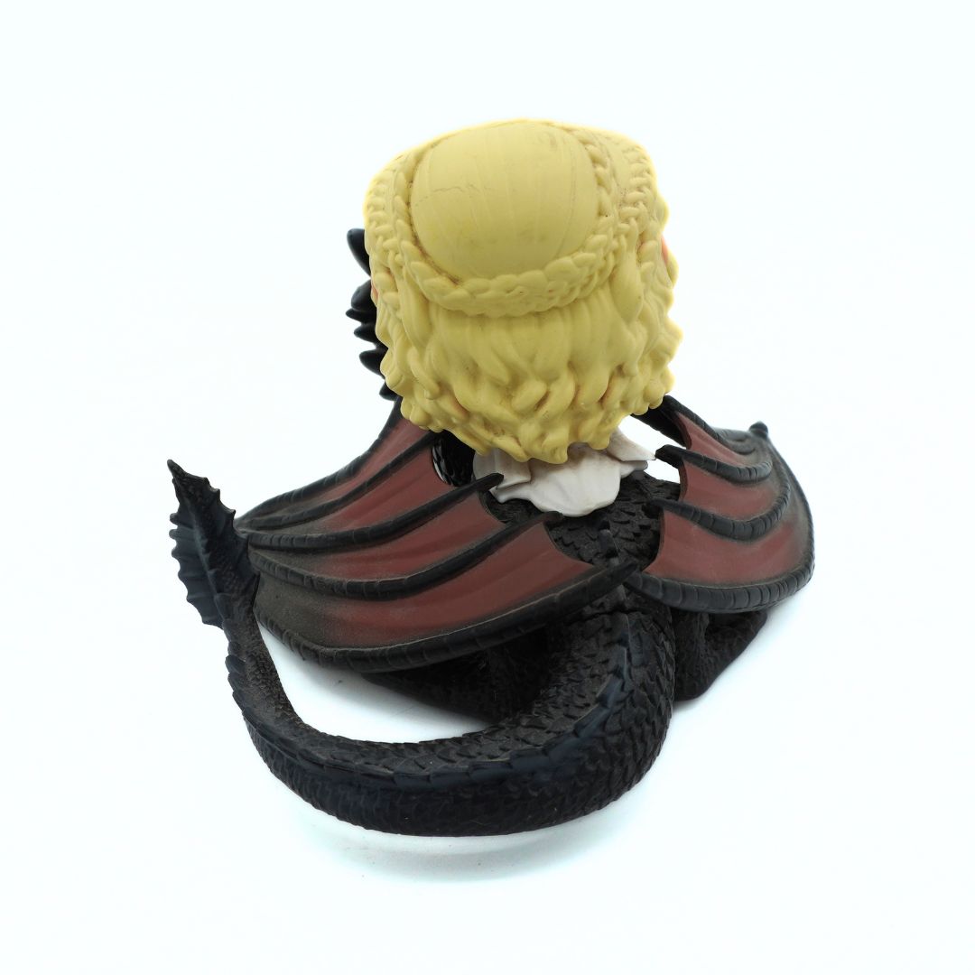 A collectible figurine of a fantasy character with textured yellow hair, wearing red and black wing-like armor, posed on a white background.