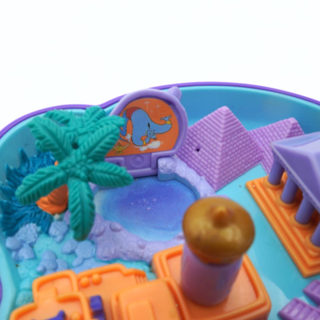 Toy playset with palm tree, beach scene, and various elements on a blue base.