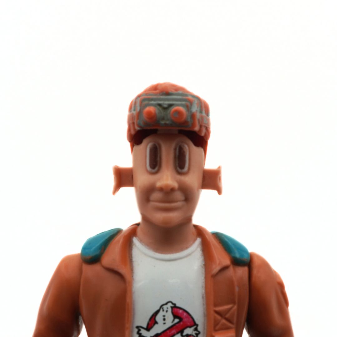 Action figure with a brown jacket and white shirt featuring a ghost logo on a white background