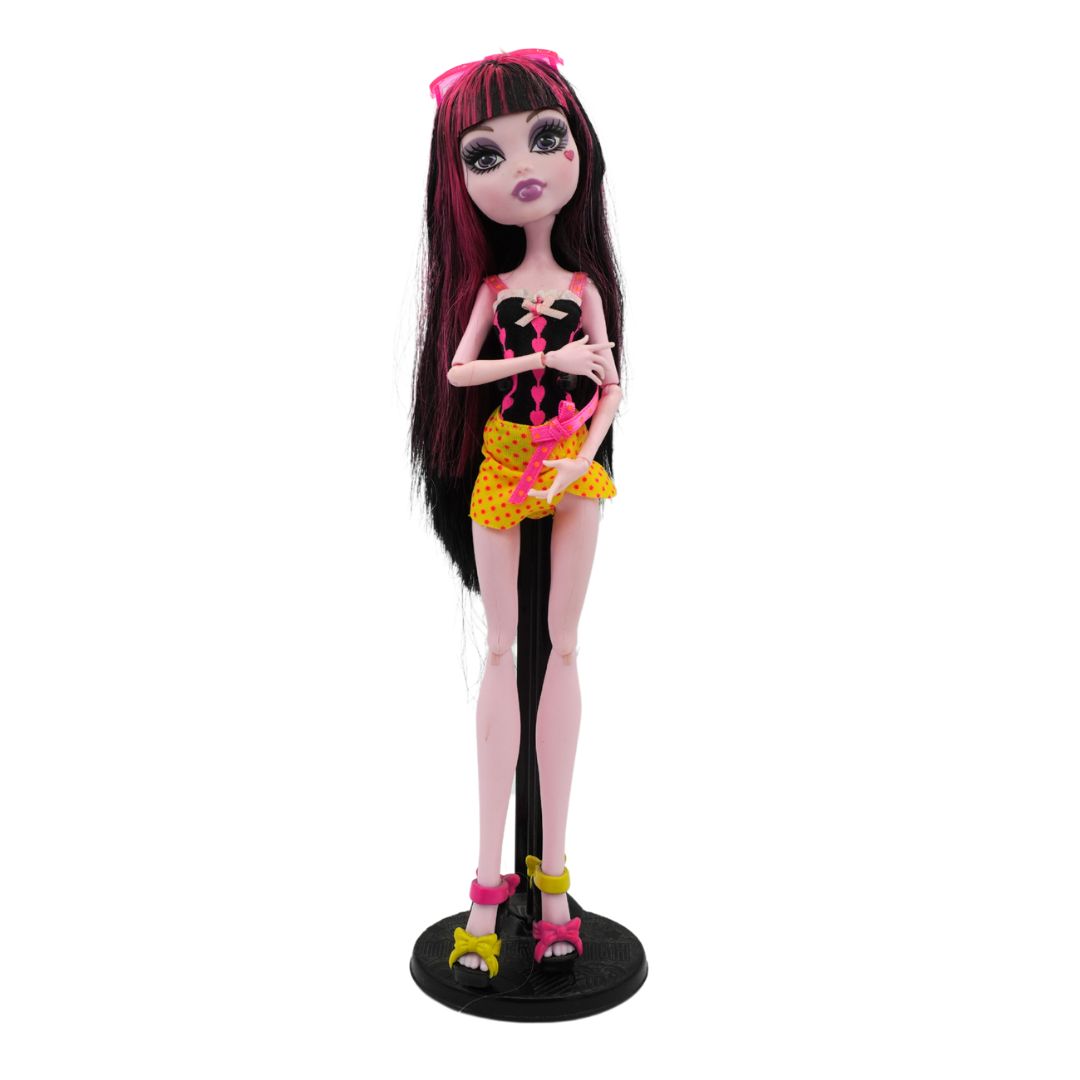 Front on photo of a 2010 Monster High Draculaura from the Gloom Beach range wearing a black shirt and yellow skirt, photographed on a black stand on a white background