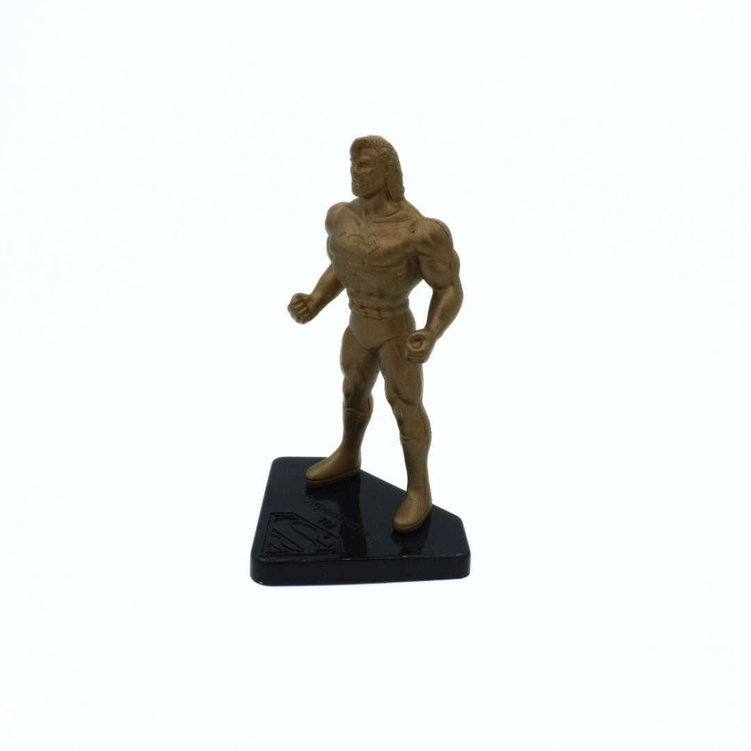 Bronze-colored superhero figure on a black base against a white background
