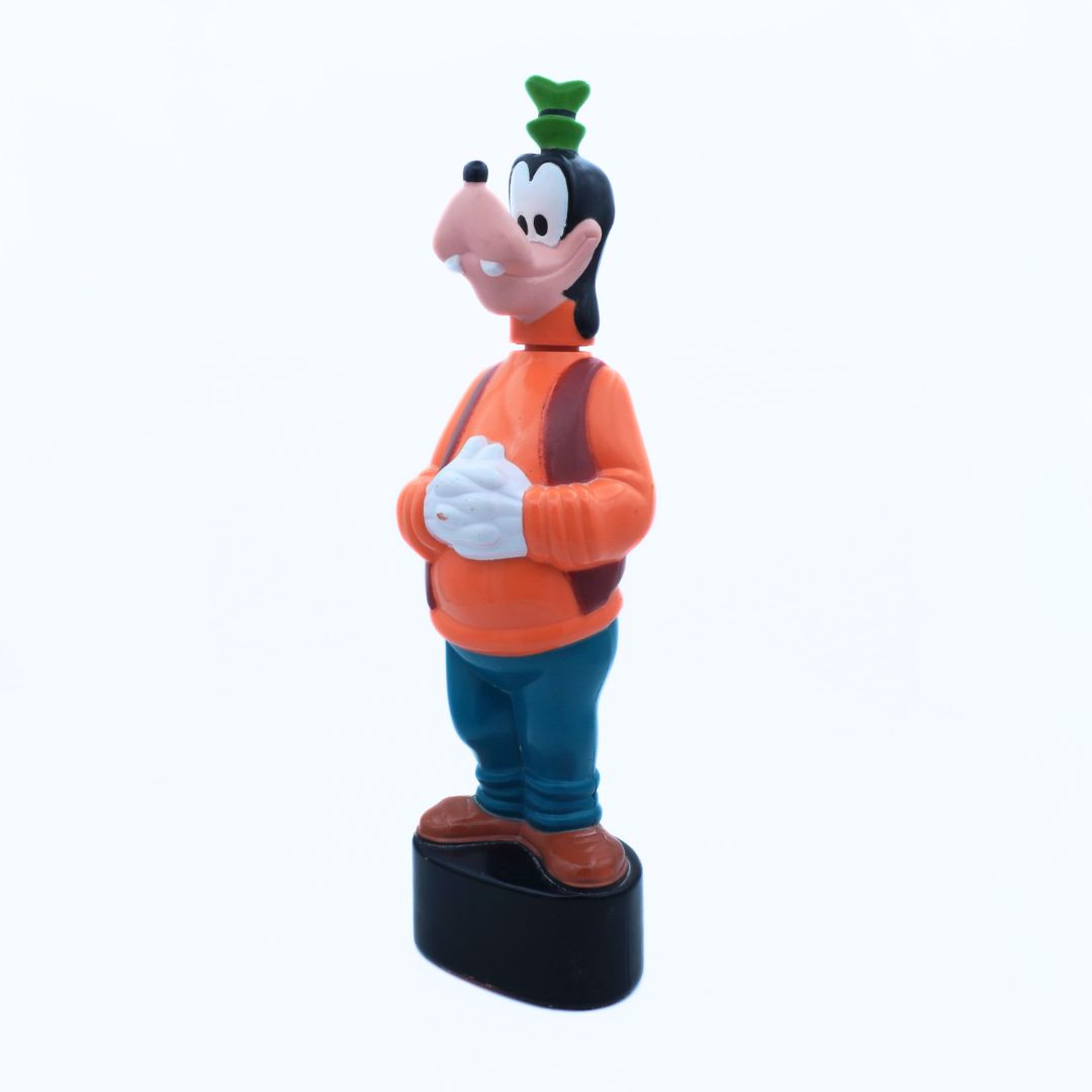 Cartoon character figurine with an orange shirt and blue pants on a white background