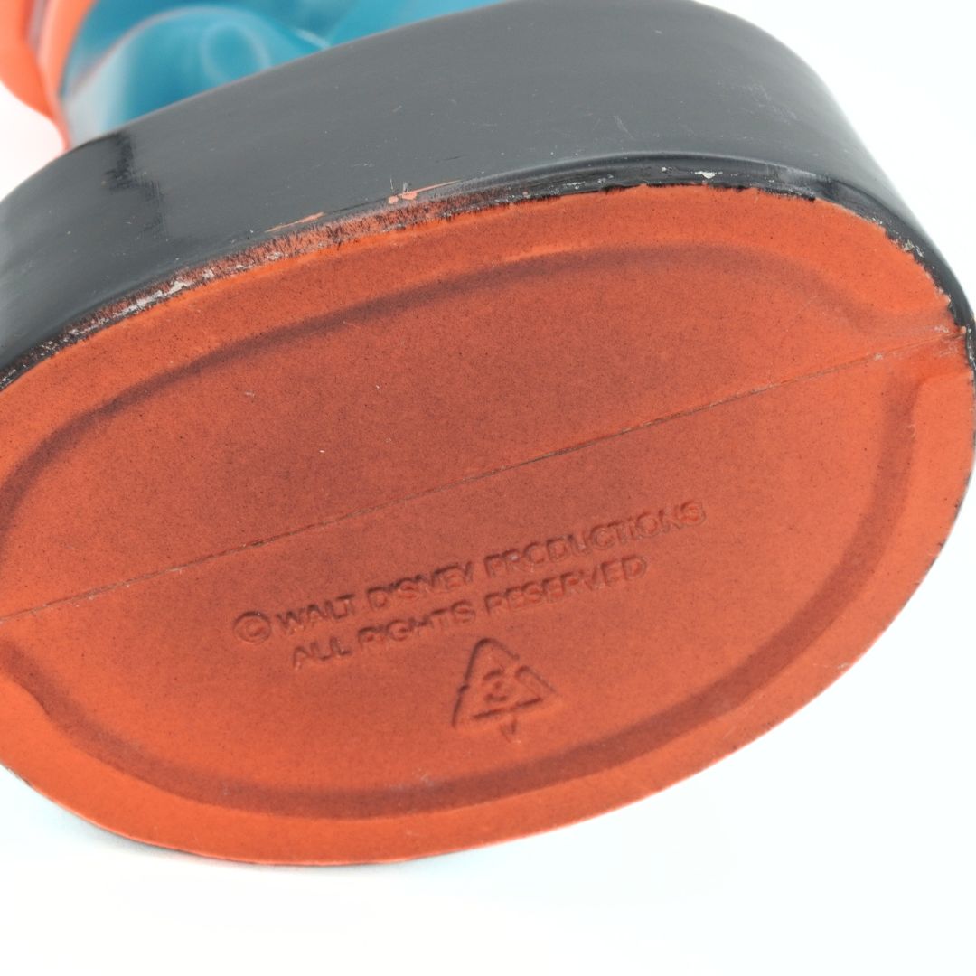 Close-up of a toy's sole with 'Walt Disney Productions' branding on a white background