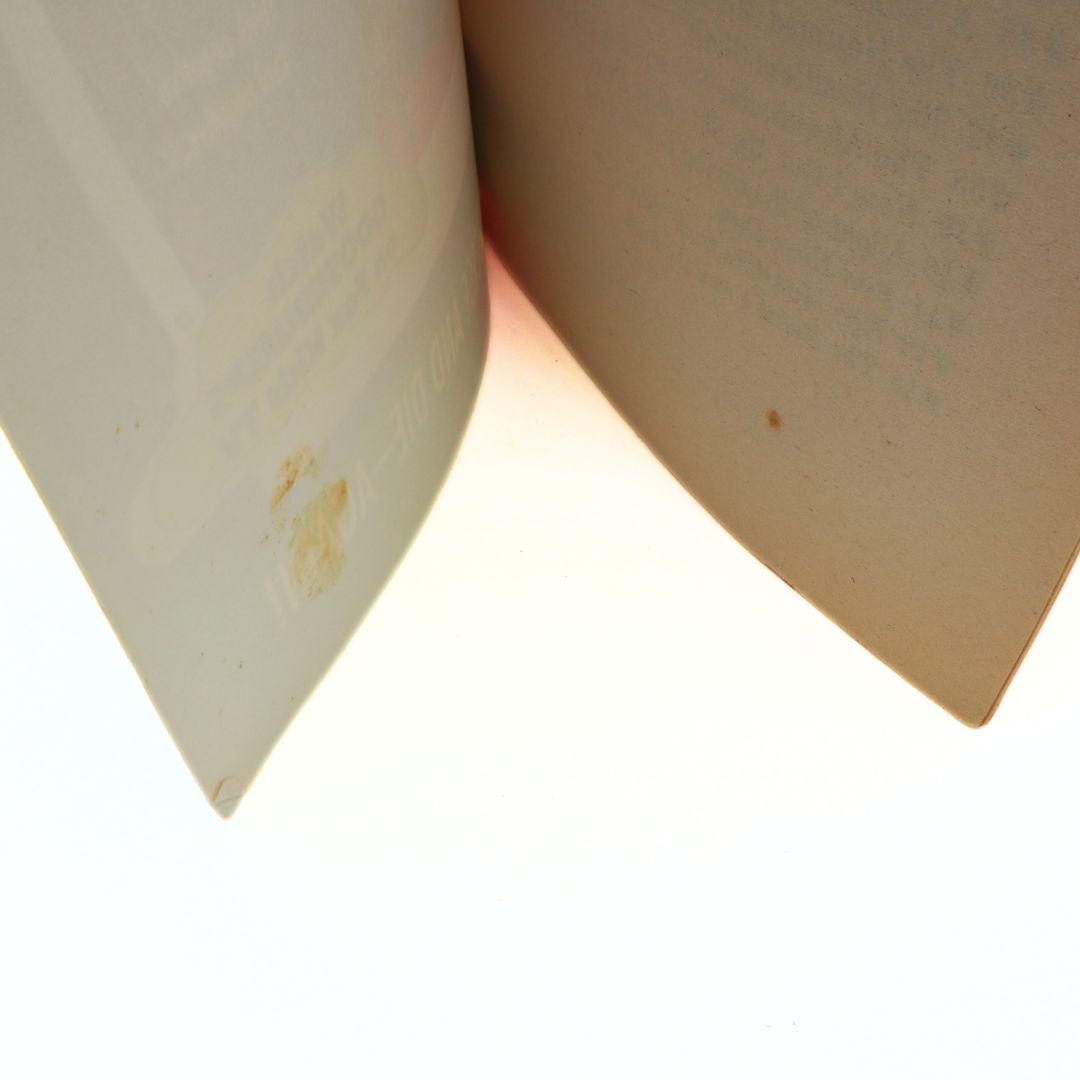 Close-up of a book corner with visible dirt and stains on a white background