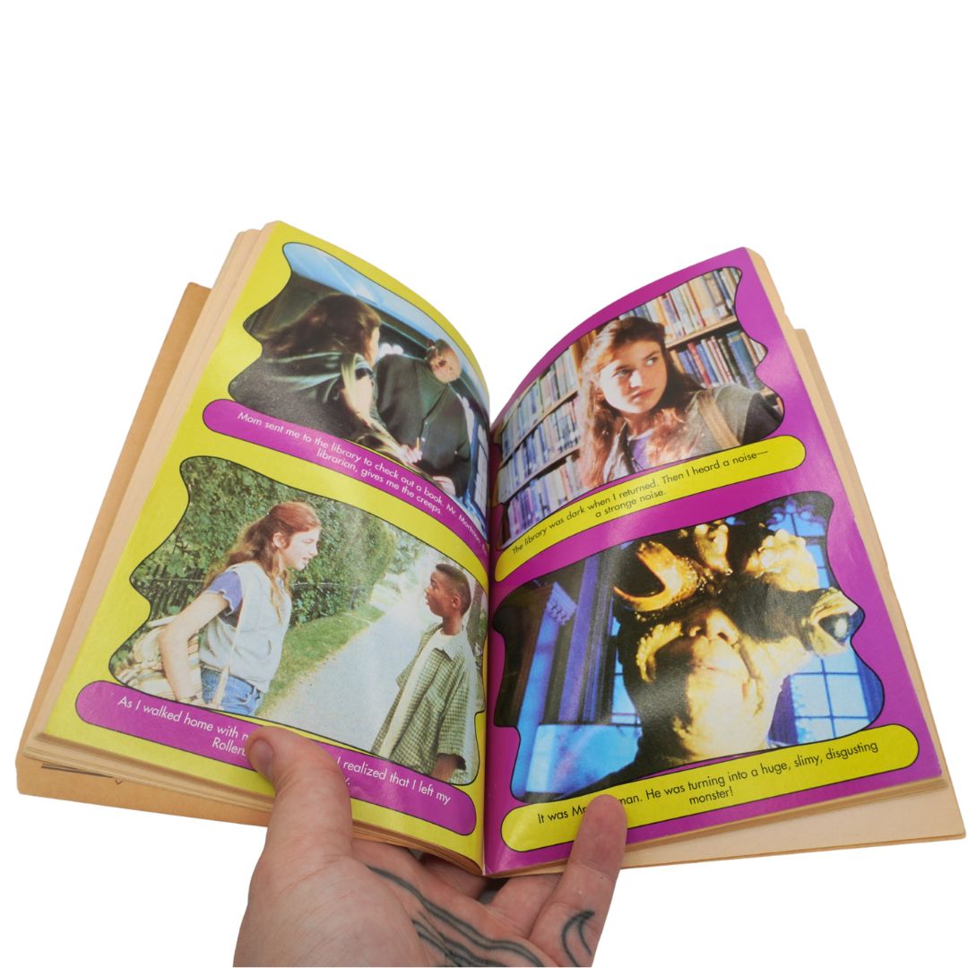 Open book with colorful illustrations and text held by a hand on a white background