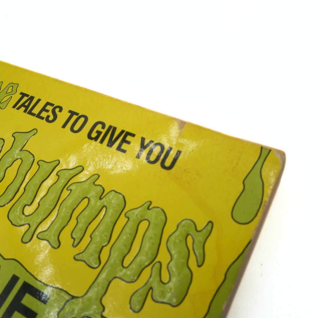 Close-up of a yellow book cover with green text on a white background