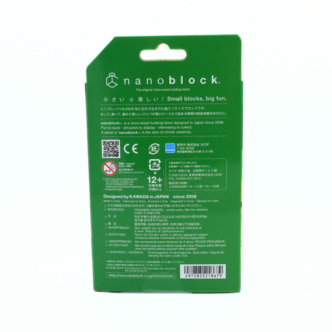The back of a green Nanoblock toy packaging card, featuring product information, safety icons, and a barcode on a plain white background.