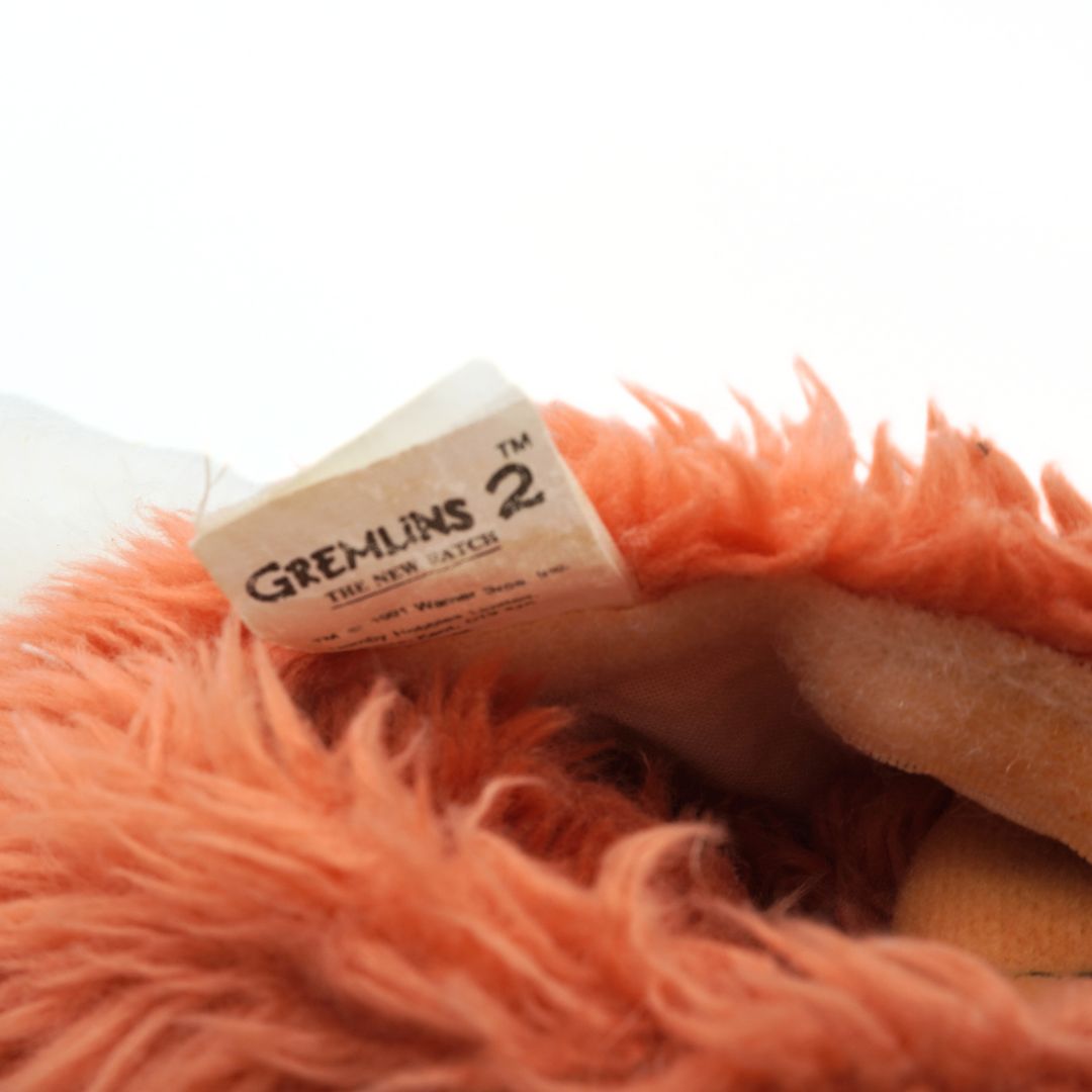 Close-up of a plush toy with a 'Gremlins 2' label on a white background