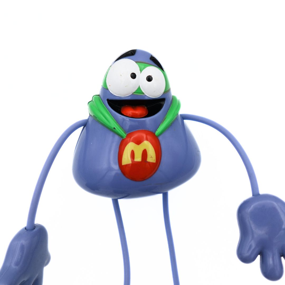 2004 McDonalds Happy Meal Grimace toy with long bendable legs with a green cape and mask