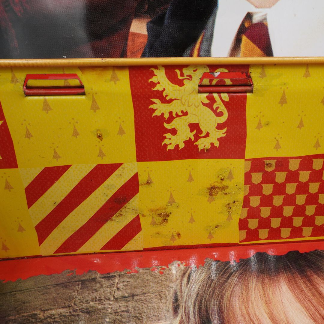Yellow and red patterned box with a lion emblem on a wooden surface