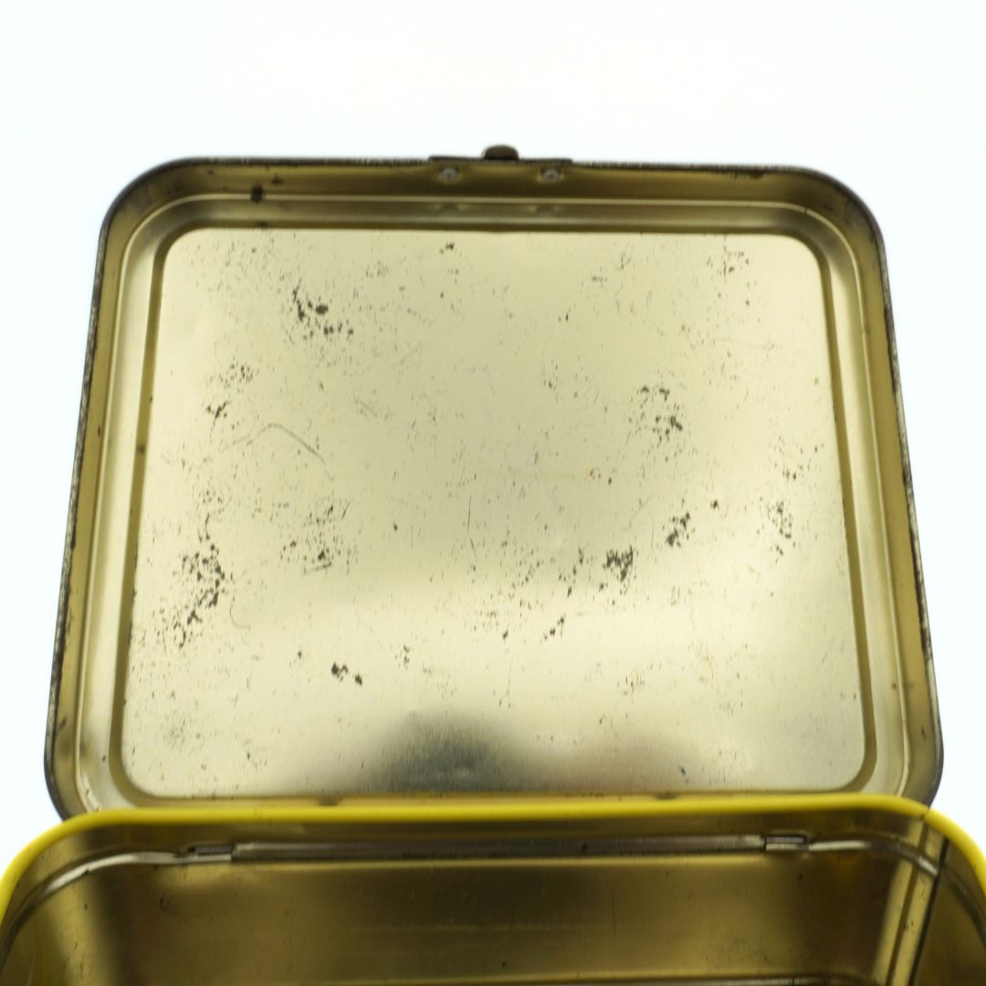 Gold-toned interior of a vintage 1999 Gumby lunch box showing some marks and wear due to its age