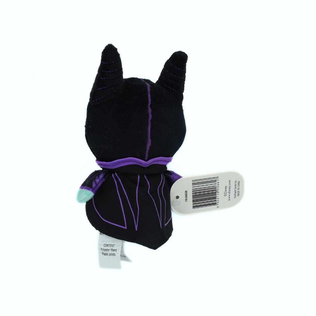 A plush toy figure of a black character with pointed ears, purple stitched details, and a purple sash, shown from the back with attached white product tags on a white background.