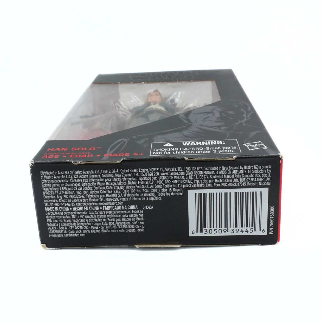 Toy figure in packaging with warning label and barcode on a white background