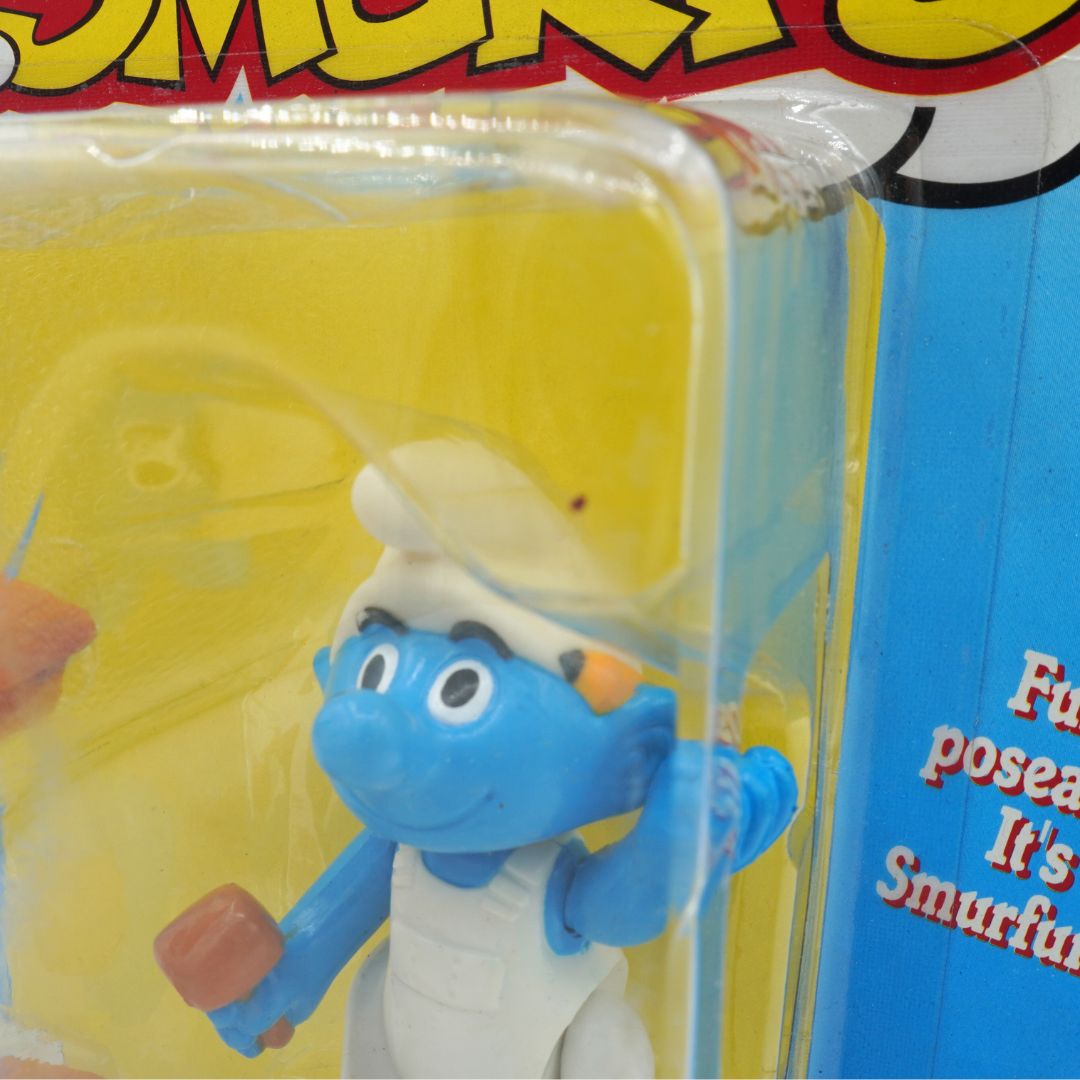 Toy Smurf figure in packaging with yellow background
