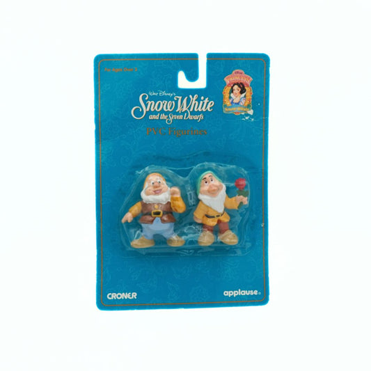 Two toy figures of dwarfs from 'Snow White' in a blue packaging with Disney branding.