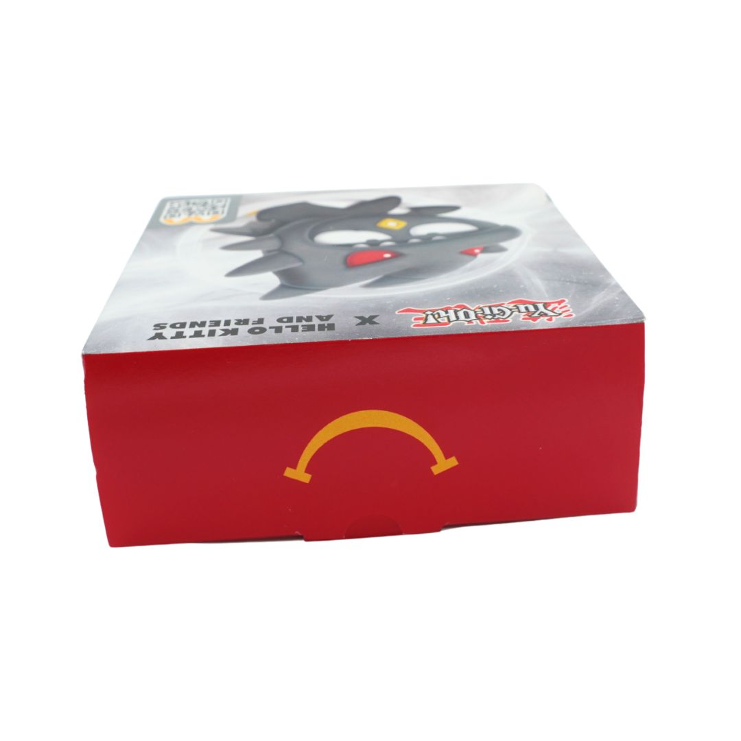 A red McDonald's Happy Meal box featuring a printed illustration of a black cat character on the top and the golden arches logo on the front, set against a plain white background.