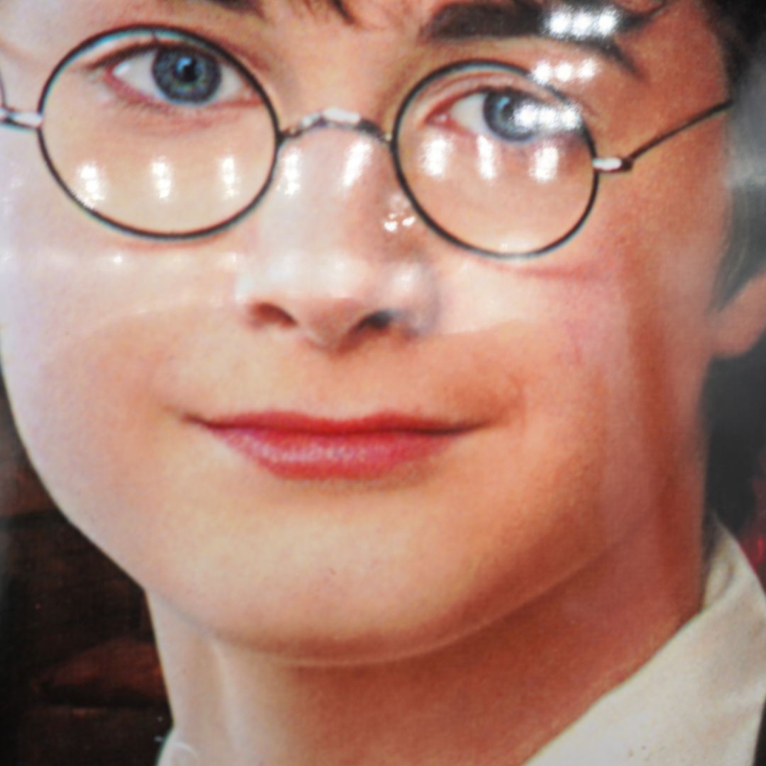 Close-up of a person wearing round glasses with a blurred background