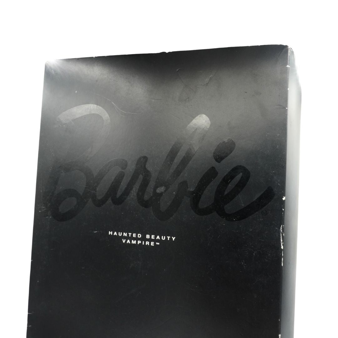 Black packaging with 'Barbie' and 'Haunted Beauty Vampire' text on a white background