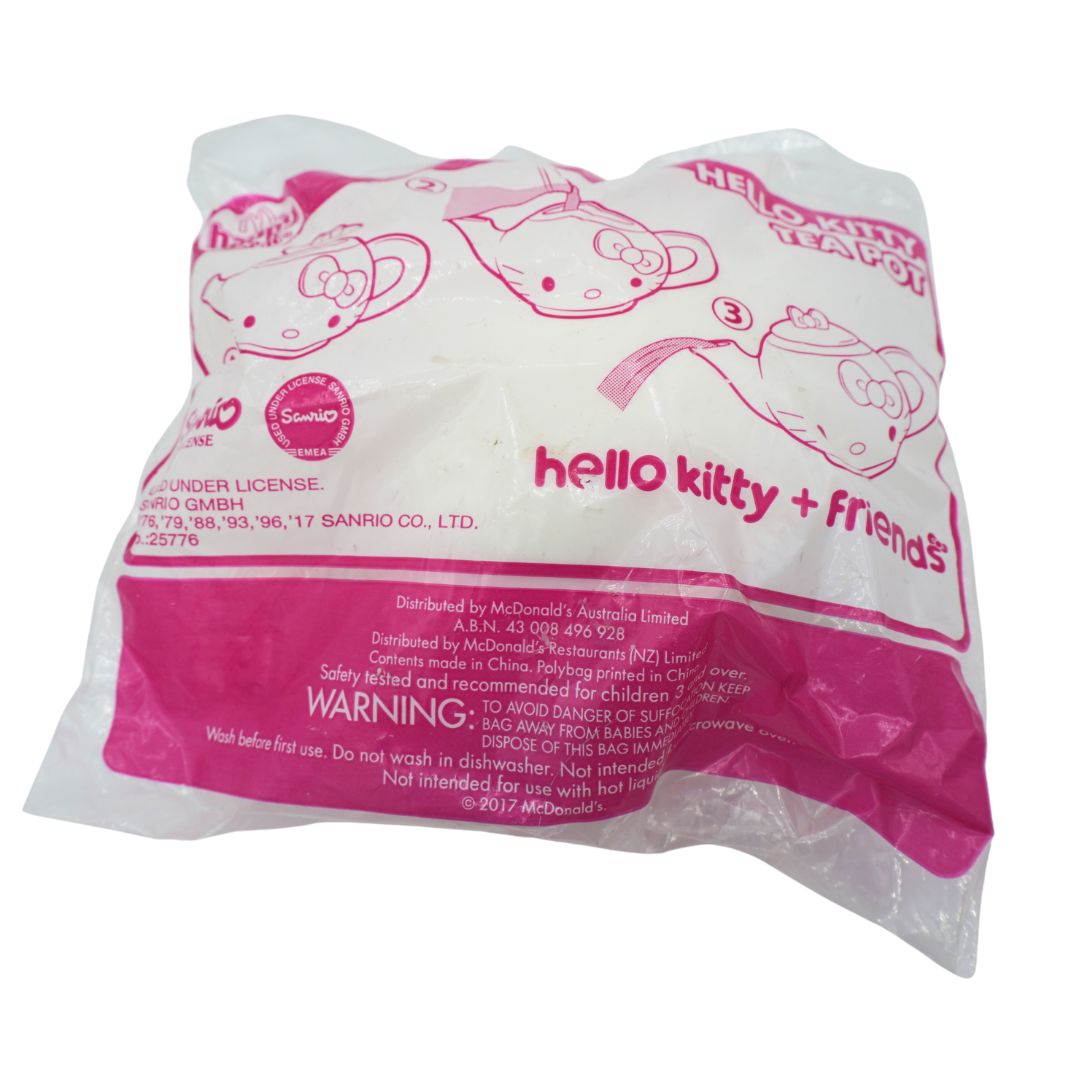 Pink and white packaging from McDonalds holding a toy teapot with a Hello Kitty theme.