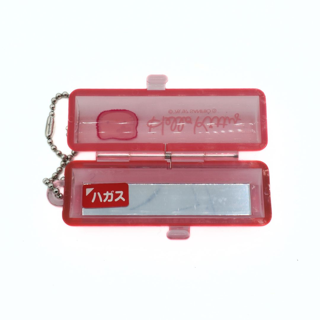 Pink Hello Kitty Lipstick holder, with an internal mirror. Sticker reading hagasu in katakana