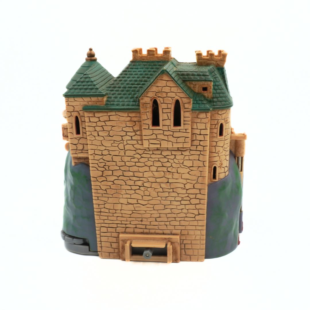 Model of a stone castle with green roof on a white background