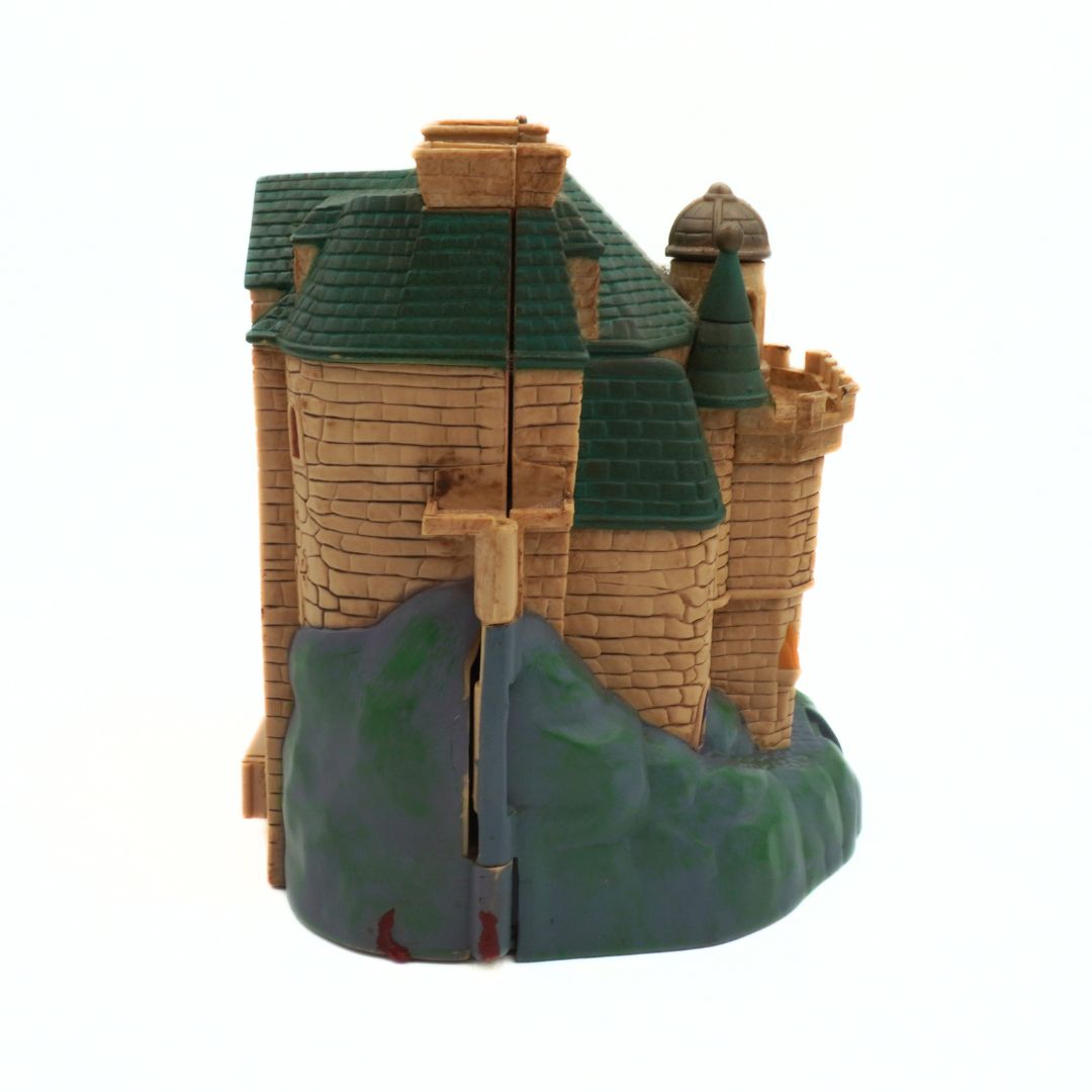 Model of a castle with green roofs on a white background