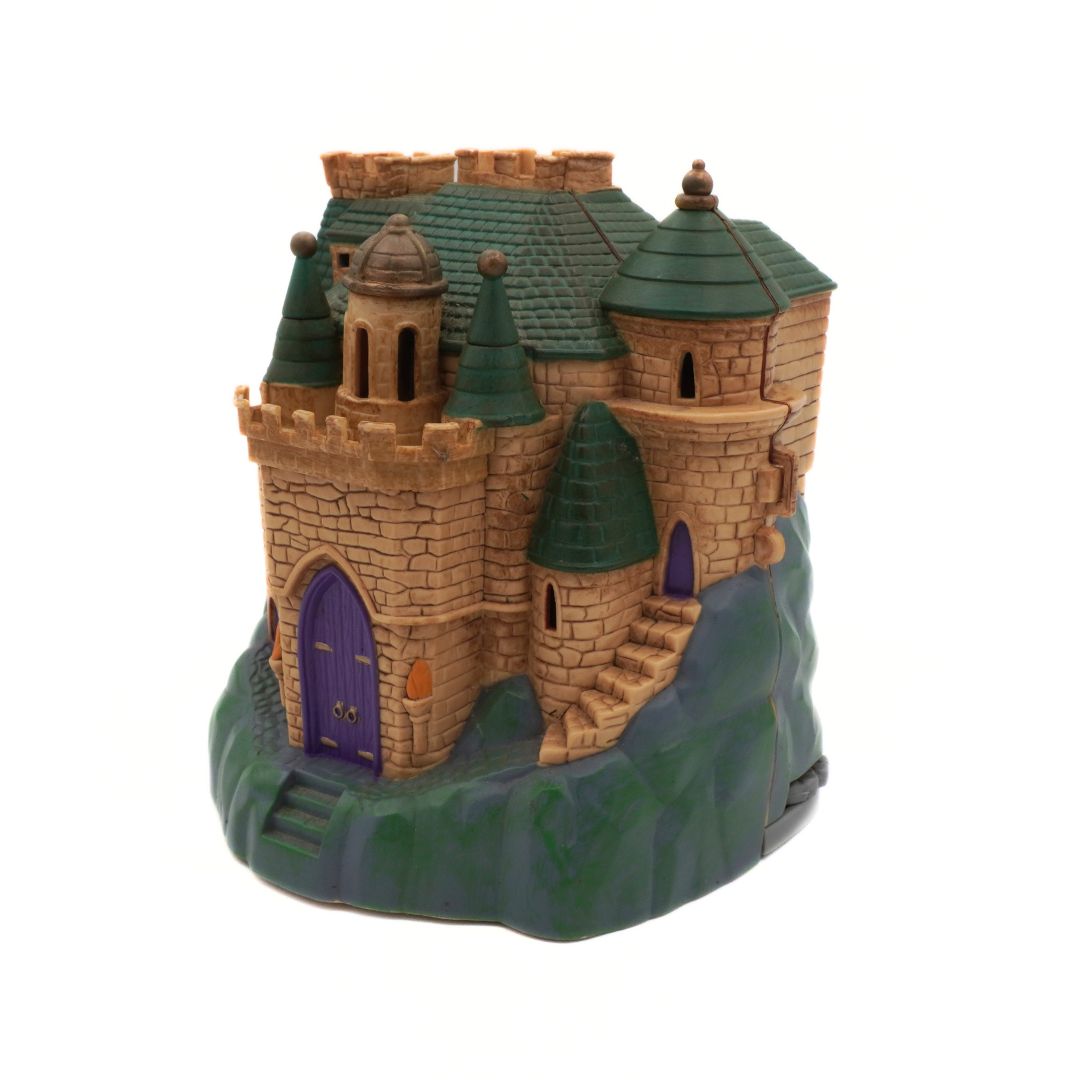 Toy castle with green roof and purple door on a white background