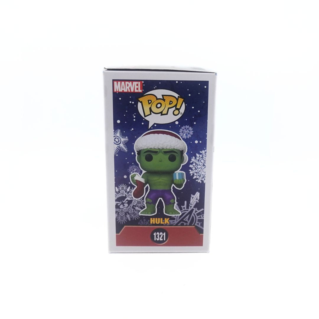 Side on photo of the Christmas 1321 Special Edition Hulk Funko Pop holding a Christmas gift and stocking