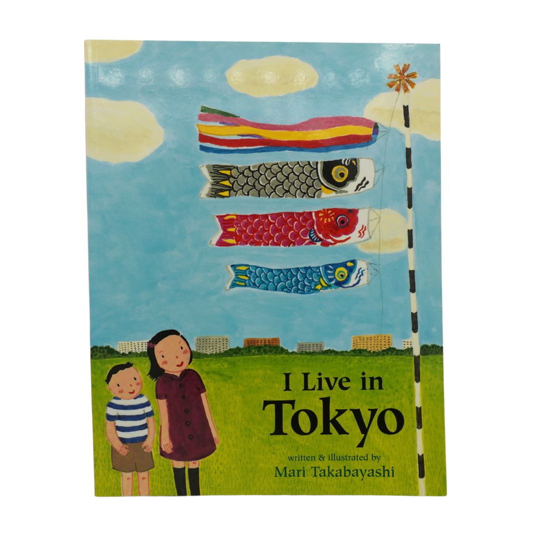 Children's book titled 'I Live in Tokyo' by Mari Takabayashi, featuring an illustration of two children standing on a green field under a blue sky with colorful koi fish flags.
