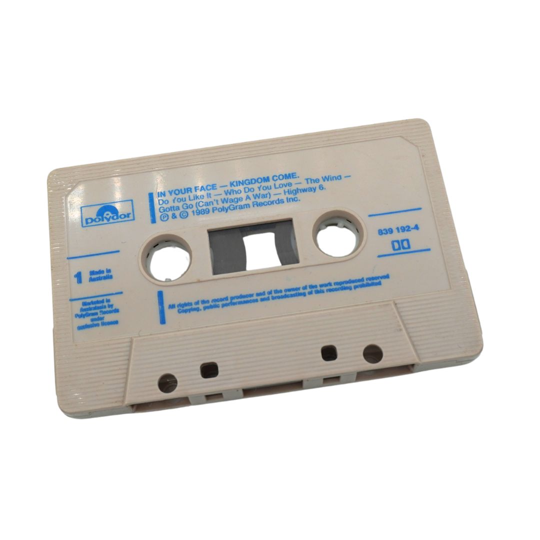 A vintage Polydor 16-track cassette tape, model 929 102-4, featuring the album 'In Your Face - Kingdom Come' by Jim Morrison's 'The Wind and the Cloud' tour. The cassette has a light beige plastic shell with blue printed text and logo, set against a plain white background.