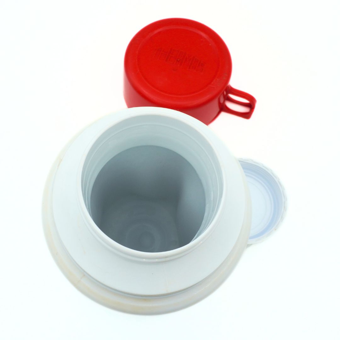 Inside the Barbie thermos from 1990, showing the inside and the replacement red lid