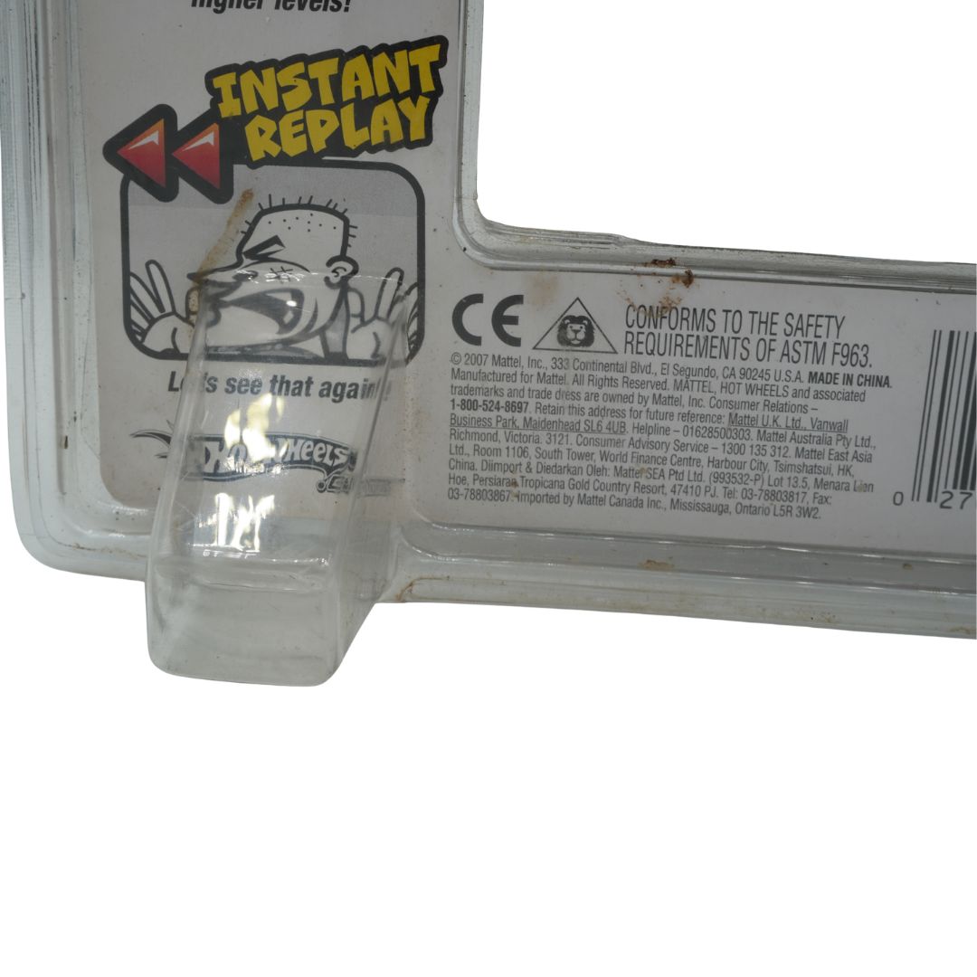 Clear plastic toy figure in front of a toy packaging with 'Instant Replay' branding.