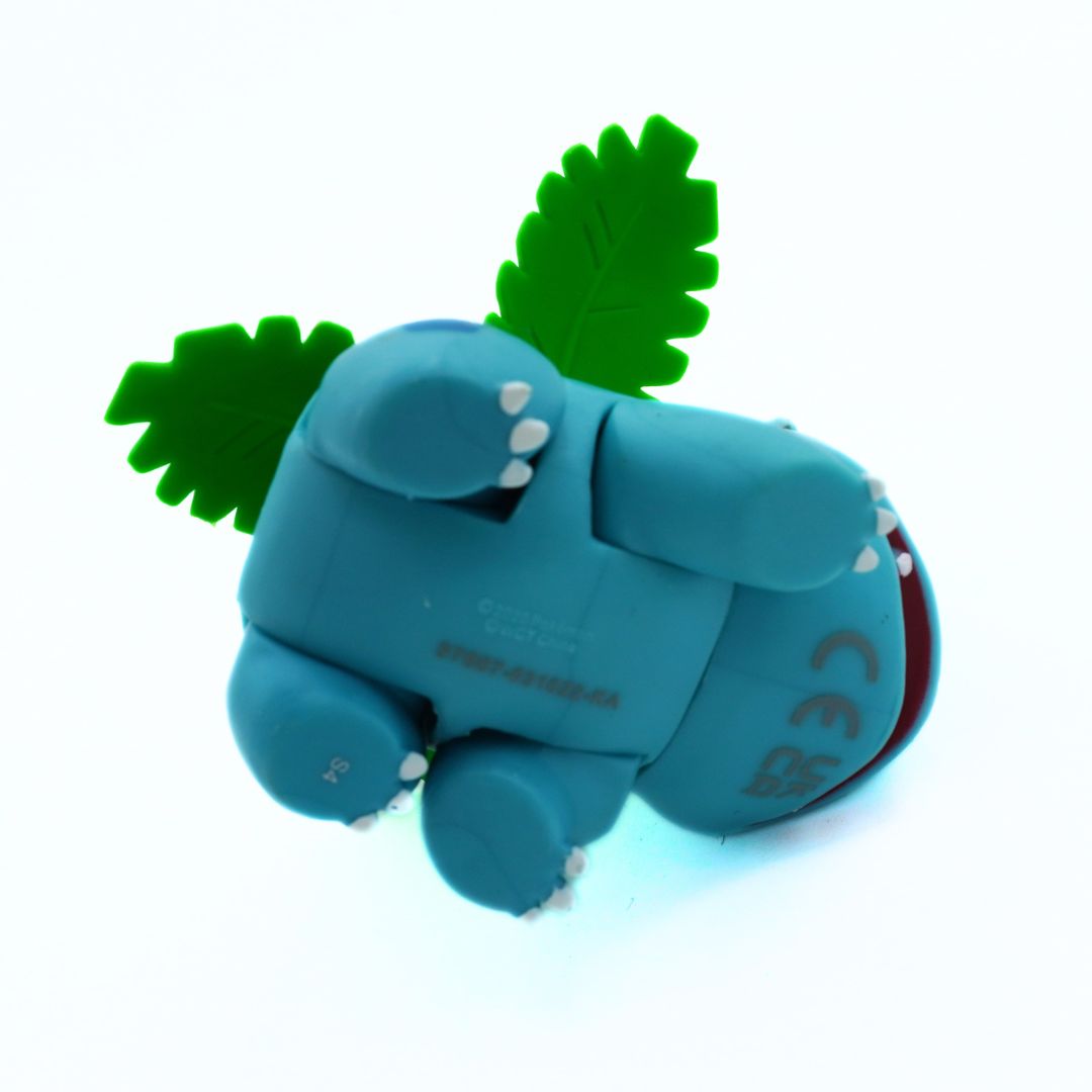Blue toy dinosaur with green spikes on a white background