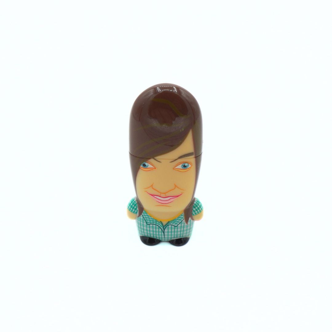 A small novelty figurine of a woman with brown hair, a green and white checkered shirt, and black shoes, centered on a plain white background.