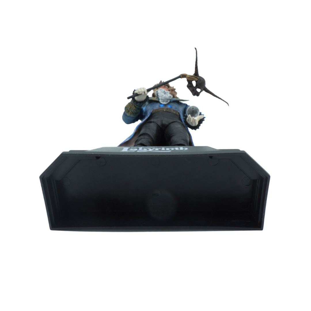 Action figure lying on a black platform with a white background
