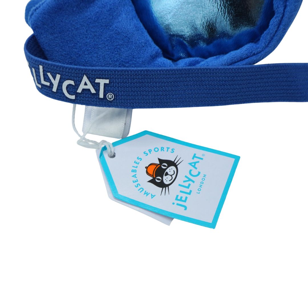 Close-up of a blue plush pair of goggles with a matching elastic band printed with the Jellycat brand name, plus a hanging product tag on a white background.