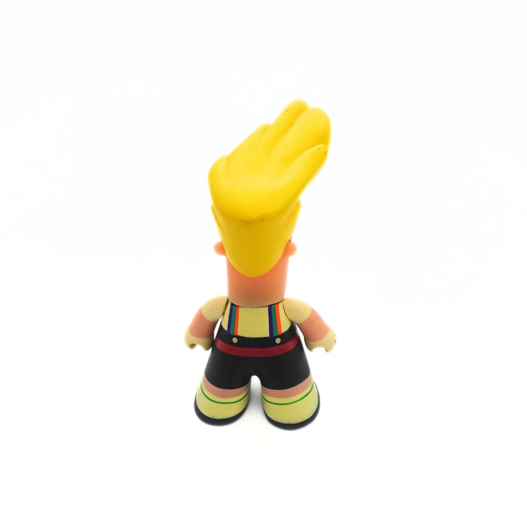 A photo of the back of a small Johnny Bravo figure wearing a button up shirt, overalls and a bumbag