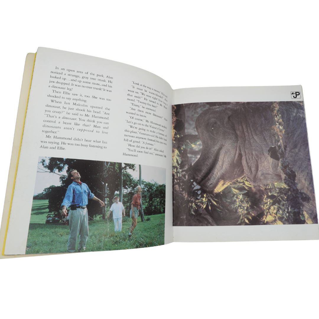 Open book with two photographs inside, one showing a man and children in a park and the other showing a tree.