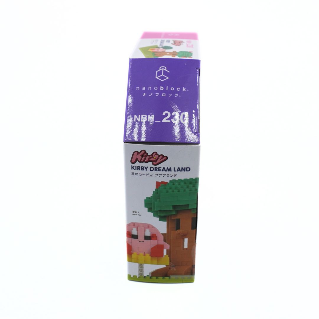 A vertical package of nanoblock NBH 230 Kirby Dream Land, featuring a purple top section with white text and a white bottom section with colorful illustrations of Kirby and a treehouse.
